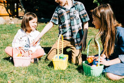Kids Laughing and Looking Through Their Easter Eggs Together  image 1