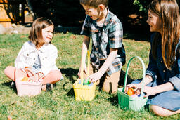 Kids Laughing and Looking Through Their Easter Eggs Together  image 2