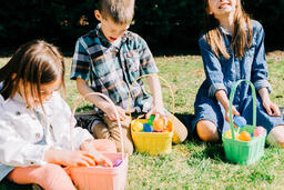 Kids Laughing and Looking Through Their Easter Eggs Together  image 2