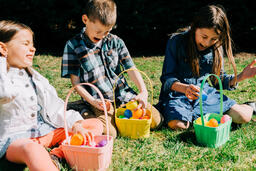 Kids Laughing and Looking Through Their Easter Eggs Together  image 1