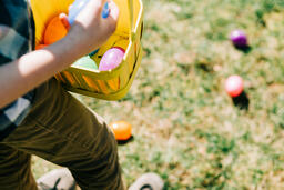 Child Putting an Egg in Their Easter Basket  image 1