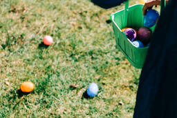 Child Putting an Egg in Their Easter Basket  image 1