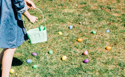 Child Putting an Egg in Their Easter Basket  image 1
