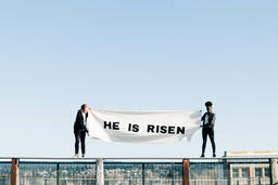 People Holding a He Is Risen Banner on a Rooftop  image 2