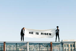 People Holding a He Is Risen Banner on a Rooftop  image 8