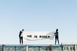 People Holding a He Is Risen Banner on a Rooftop  image 7