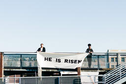 People Holding a He Is Risen Banner on a Rooftop  image 7