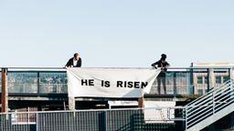 People Holding a He Is Risen Banner on a Rooftop  image 5