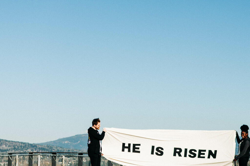 People Holding a He Is Risen Banner on a Rooftop large preview