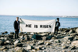 People Holding a He Is Risen Banner at the Beach  image 2