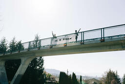 People Holding a He Is Risen Banner Over a Bridge  image 2