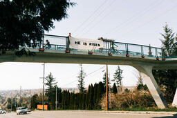 People Holding a He Is Risen Banner Over a Bridge  image 1