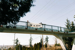 People Holding a He Is Risen Banner Over a Bridge  image 3