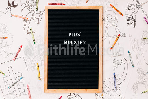 Kids' Ministry Letter Board Surrounded by Crayons and Coloring Pages