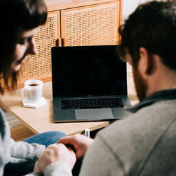 Couple Praying Together During Church at Home on a Laptop  image 2