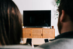 Couple in Living Room Looking at Their Phones in Front of a TV  image 5