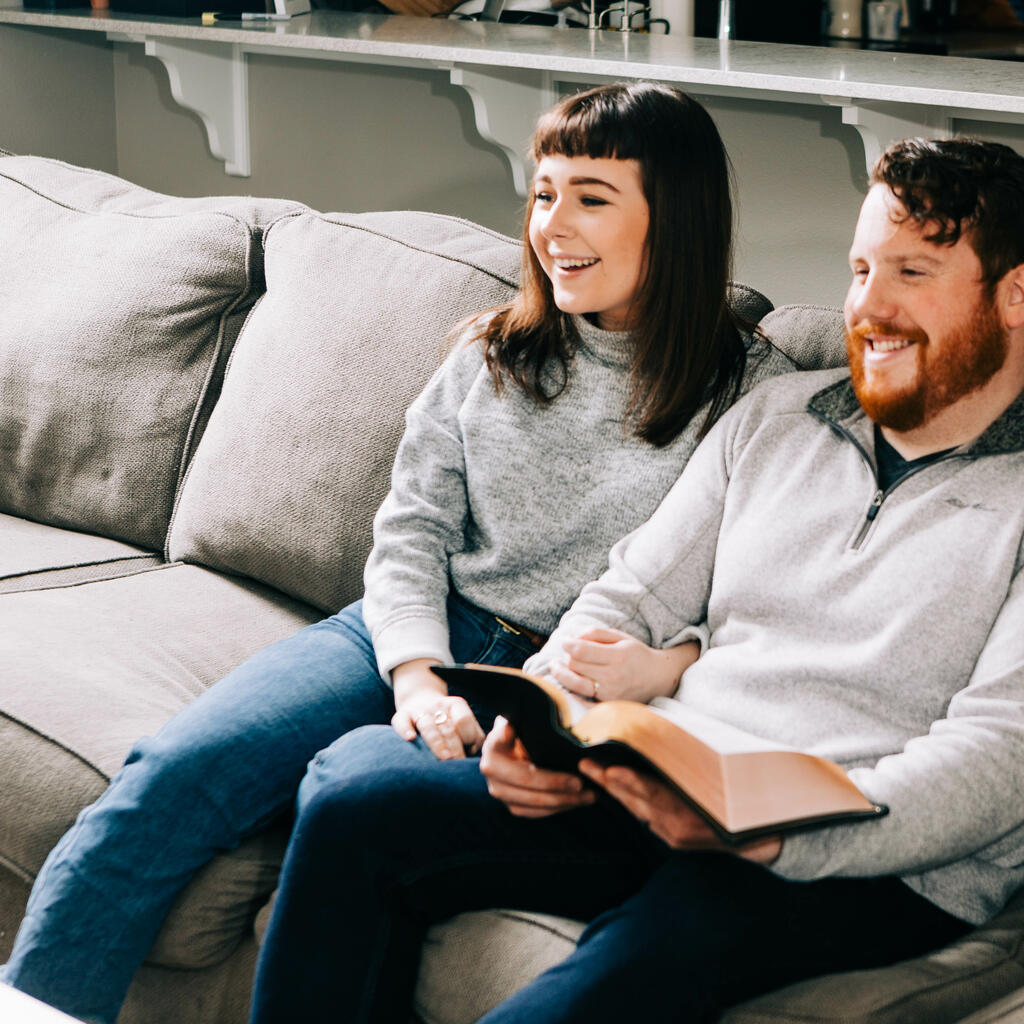 Couple Watching Church at Home with a Bible large preview