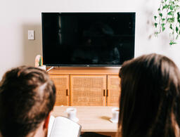 Couple Watching Church at Home on a TV with a Bible  image 2