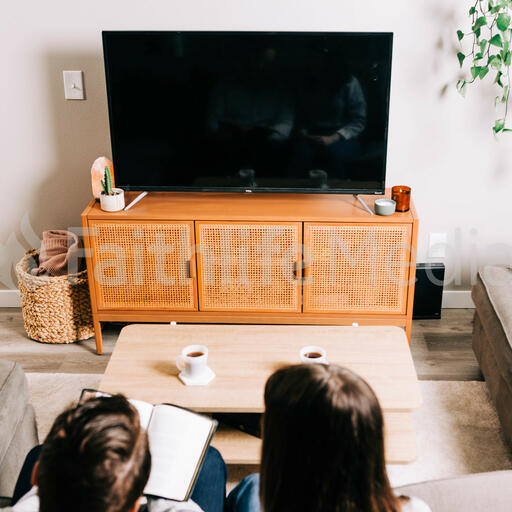 Couple Watching Church at Home on a TV with a Bible