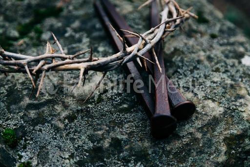 The Crown of Thorns and Crucifixion Nails on a Rock in Nature