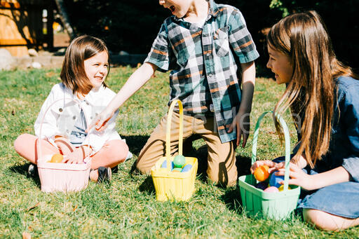 Kids Laughing and Looking Through Their Easter Eggs Together