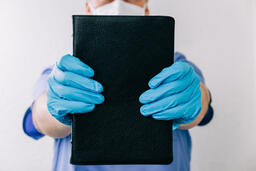Doctor Holding out a Bible  image 1