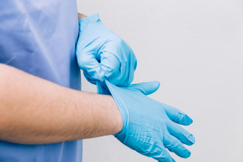 Doctor Putting Medical Gloves On large preview