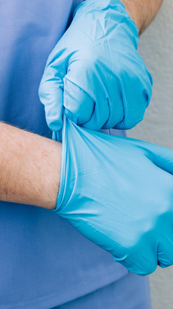 Doctor Putting Medical Gloves On large preview