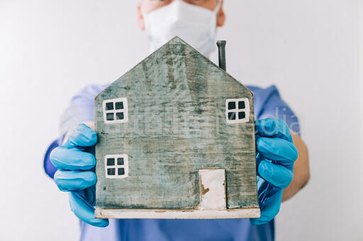 Doctor Holding Out a Wooden House