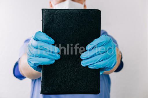 Doctor Holding out a Bible