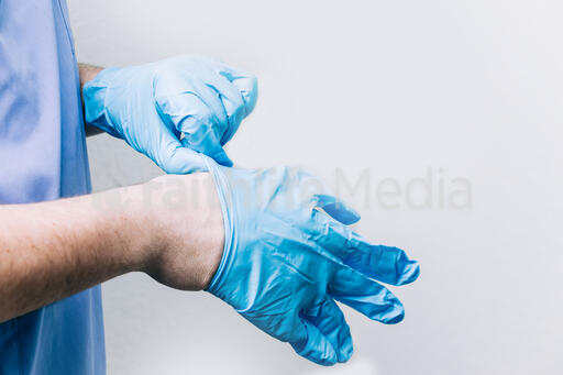 Doctor Putting Medical Gloves On