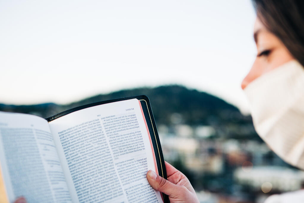 Woman Wearing a Face Mask and Reading the Bible large preview