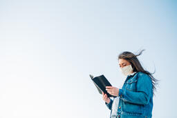 Woman Wearing a Face Mask and Reading the Bible  image 1