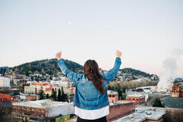 Woman with Hands Raised in Worship on a Rooftop  image 2