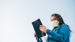 Woman Wearing a Face Mask and Reading the Bible  image 2