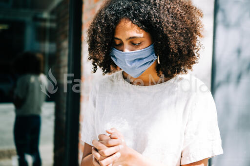Woman Wearing a Mask and Praying