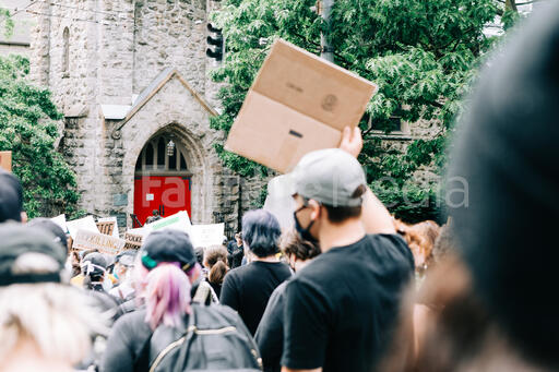 Peaceful Protesters Marching by a Church Building