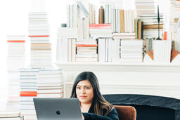 Woman Studying on a Laptop in a Living Room Full of Books  image 12