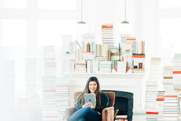 A Woman Studying on an iPad in a Living Room Full of Books  image 2