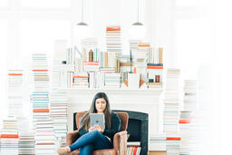 A Woman Studying on an iPad in a Living Room Full of Books  image 6