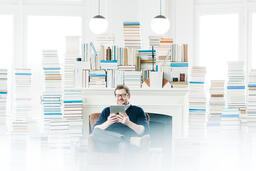 Man Studying on an iPad in a Living Room Full of Books  image 2