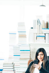 Woman Studying on an iPhone in a Living Room Full of Books  image 12