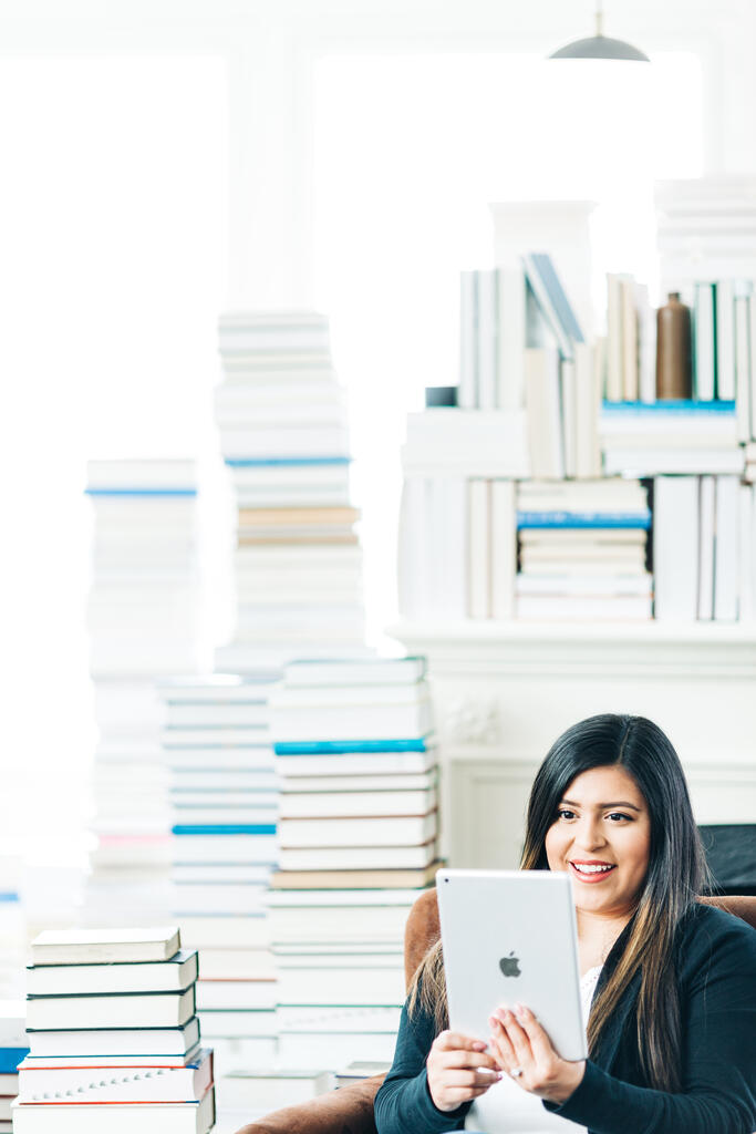Woman Studying on an iPad in a Living Room Full of Books large preview