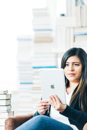 Woman Studying on an iPad in a Living Room Full of Books  image 5