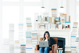 Woman Studying on a Laptop in a Living Room Full of Books  image 4