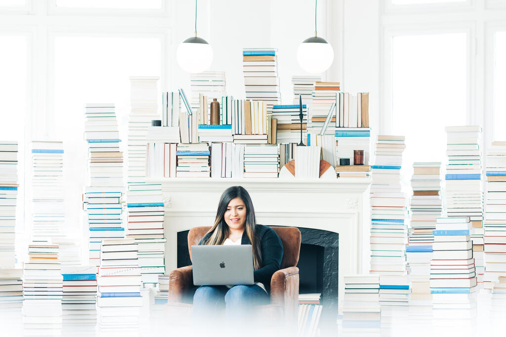 Woman Studying on a Laptop in a Living Room Full of Books large preview