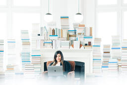 Woman Studying on a Laptop in a Living Room Full of Books  image 3