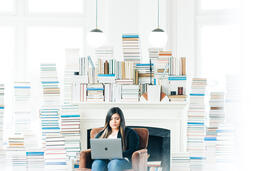 Woman Studying on a Laptop in a Living Room Full of Books  image 4