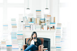 Woman Studying on an iPhone in a Living Room Full of Books  image 3