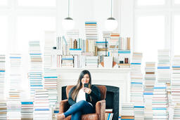 Woman Studying on an iPhone in a Living Room Full of Books  image 5